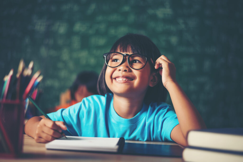 thoughtful-little-girl-with-book-near-school-board
